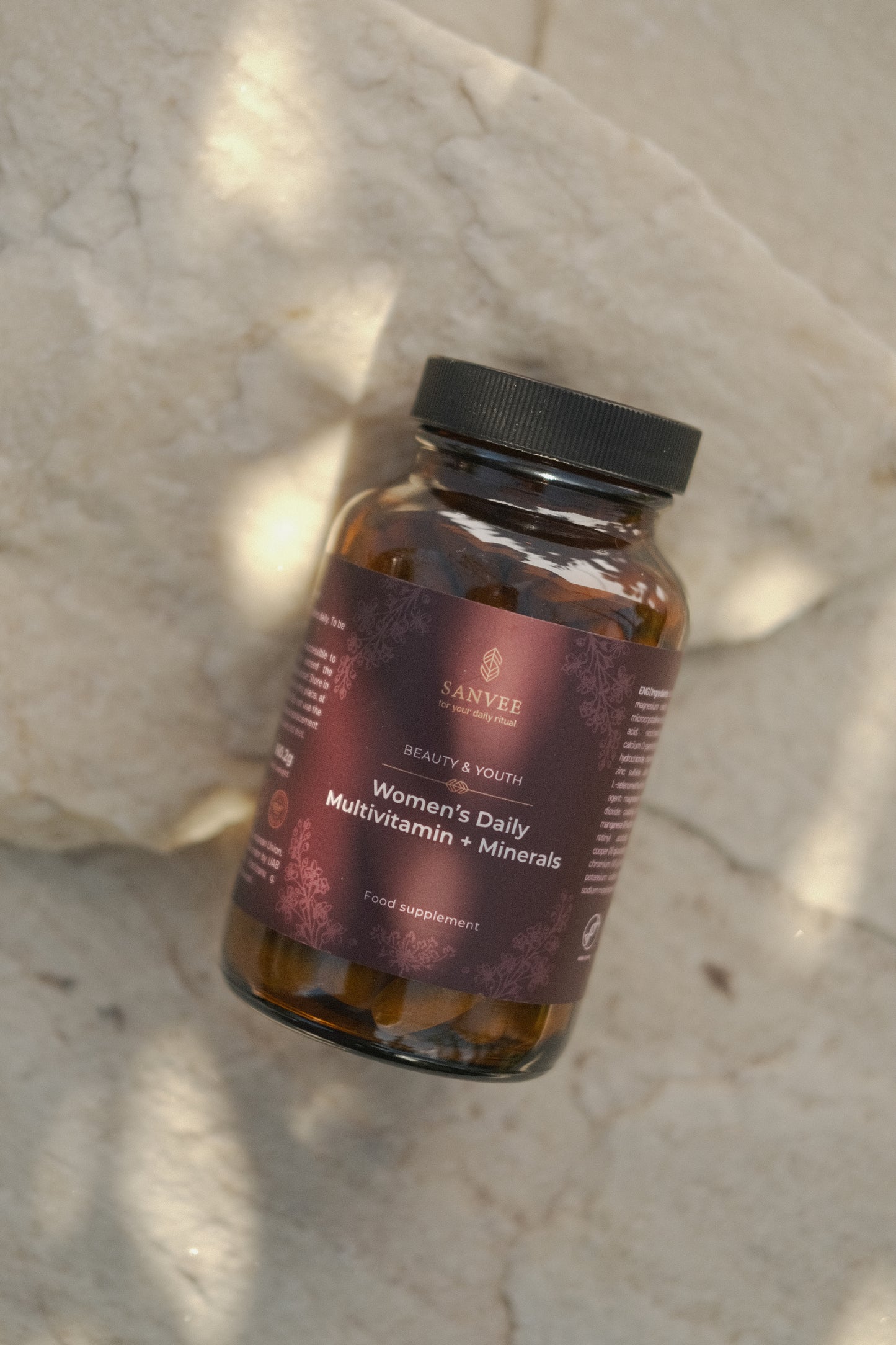 Sanvee women's daily multivitamin bottle on stone surface in natural light